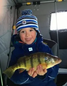 A young boy holding a fish in his hands.