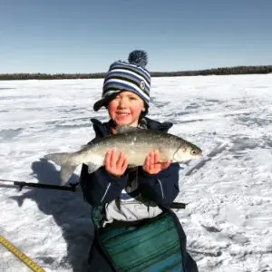 A young boy holding a fish in his hands.