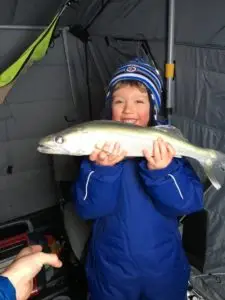 A young boy holding a fish in his hands.