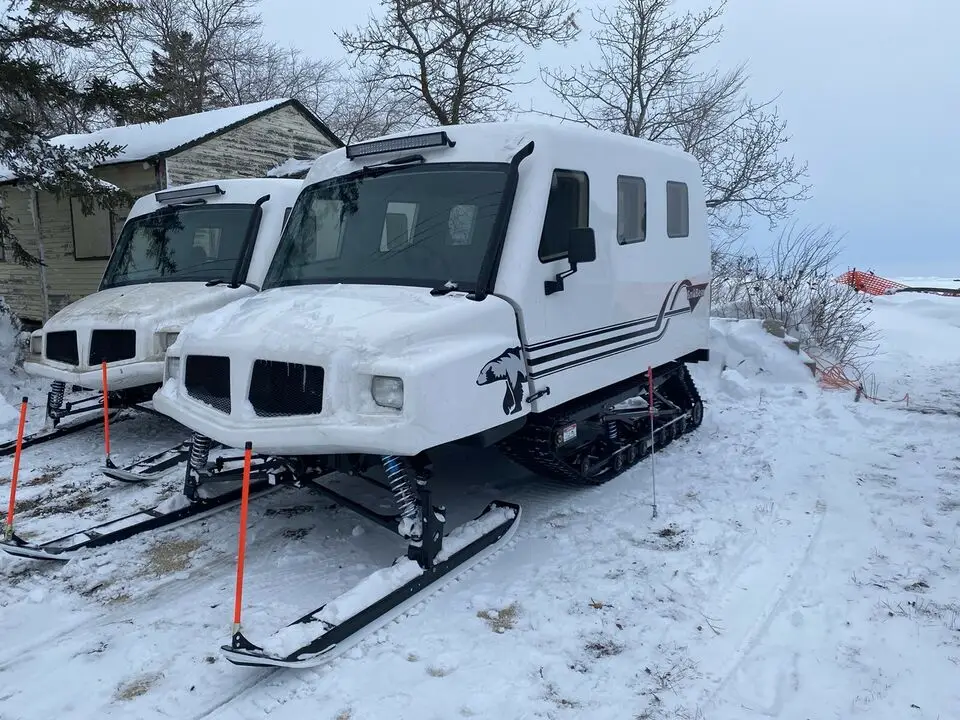 A couple of snowmobiles parked in the snow.