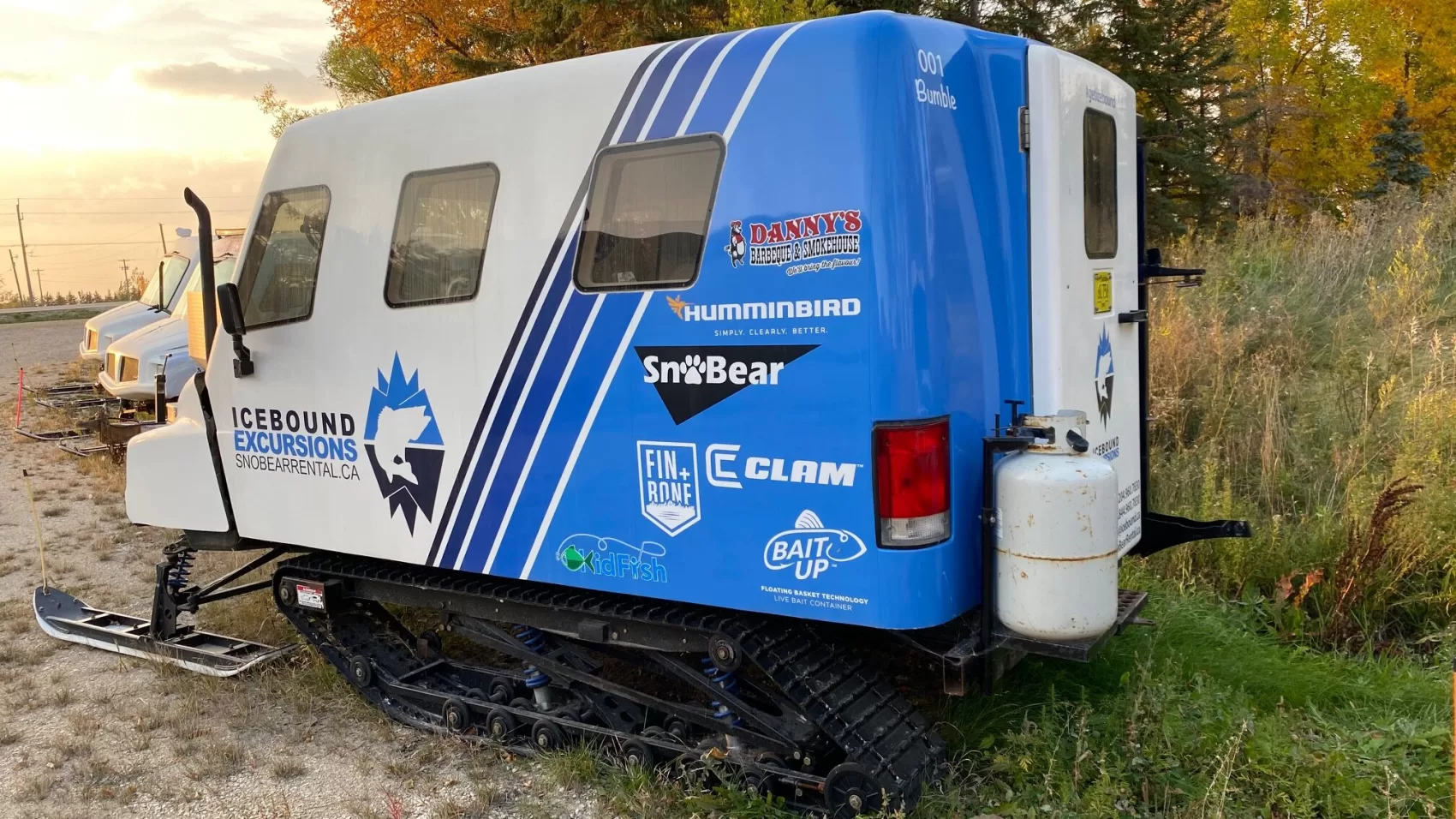 A small blue and white truck parked on the side of a road.