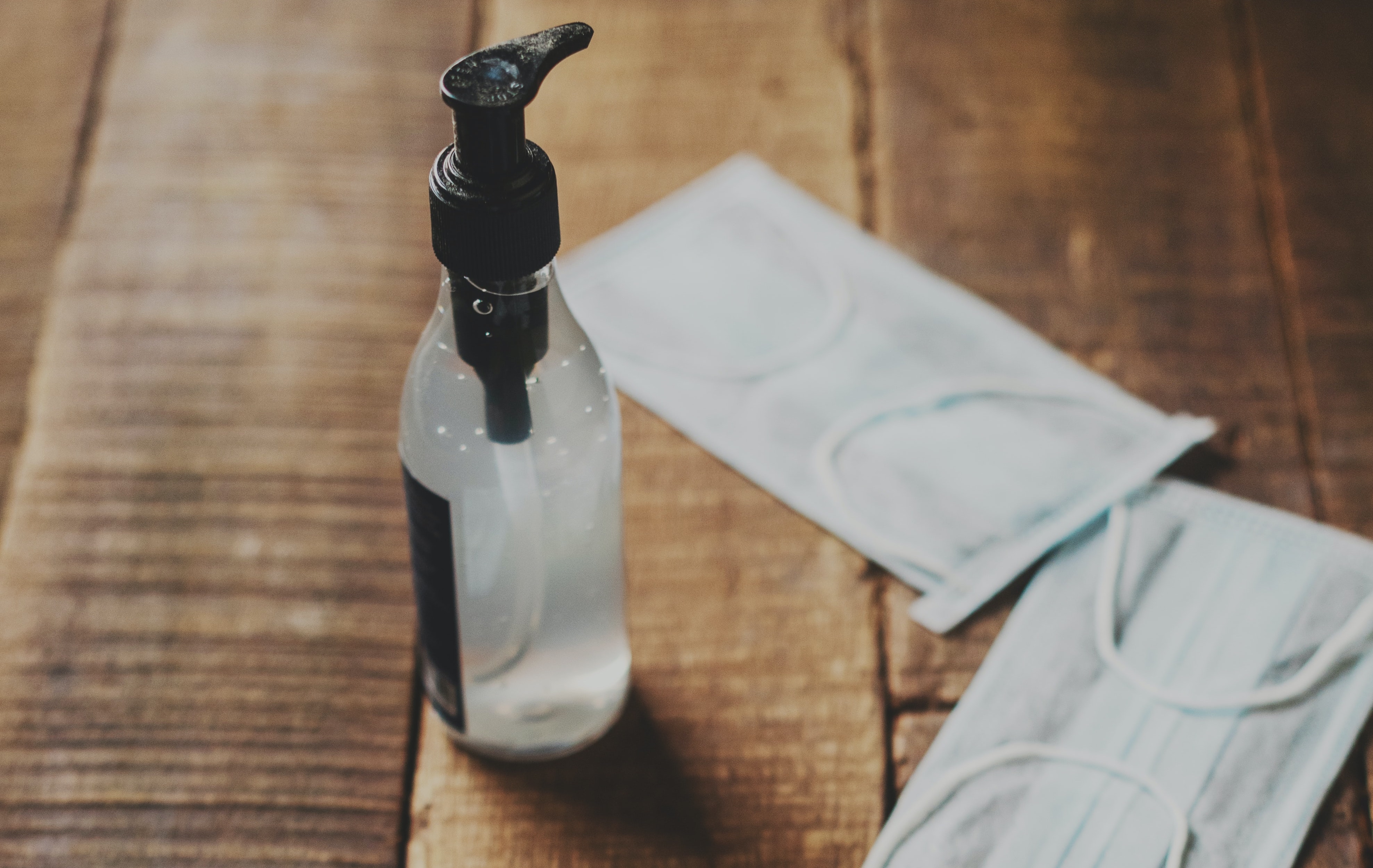 A bottle of hand sanitizer sitting on top of a wooden table.