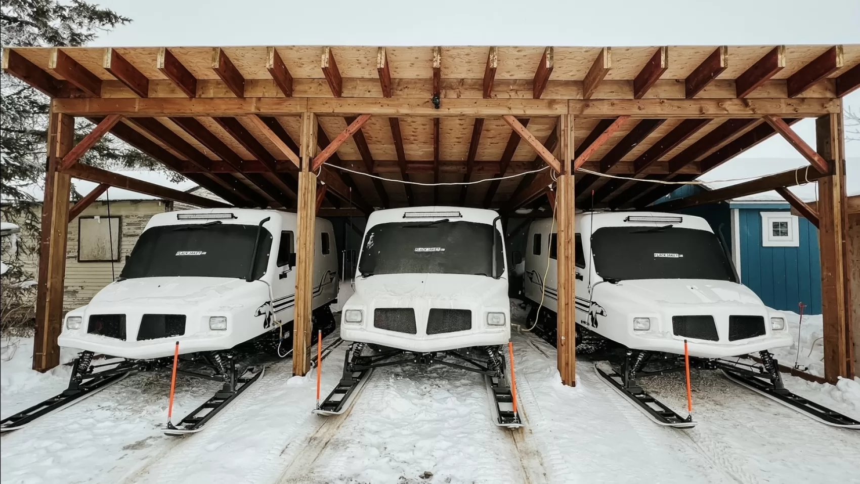 A group of three buses parked in the snow.