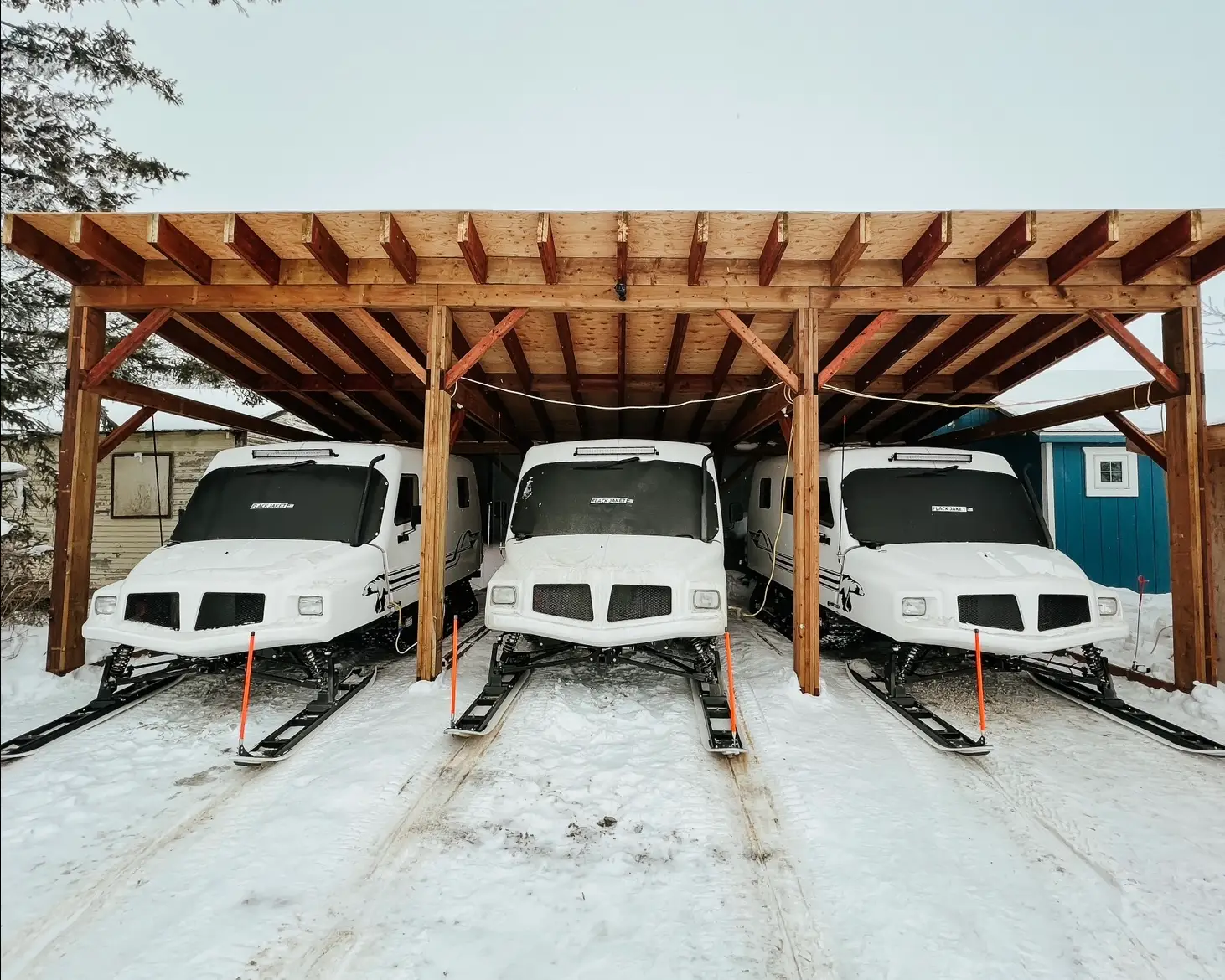 A group of three buses parked in the snow.