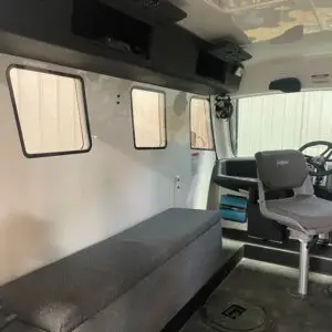 A couch and chair in the back of an ambulance.