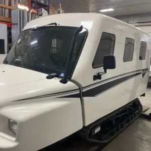 A white truck parked in a garage with other vehicles.