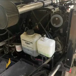 A car with two jugs of water and a hose attached to it.